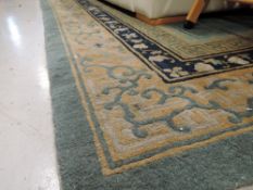 A traditional carpet square, in shades of green , blue and ochre , 365 x 265cm, small tear near