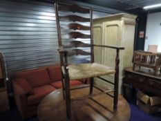 A traditional oak ladder back rush seated country carver chair