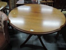 A modern extending dining table, in a light colour, having shaped edge, possibly Rossmore or similar
