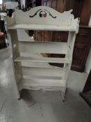 A small painted Art Nouveau style open bookshelf, width approx. 52cm