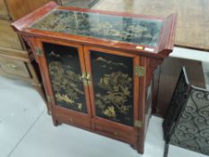An Oriental side/drinks cabinet having bar top over cupboard section with twin base drawers, width