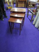An early 20th Century mahogany nest of three tables, having square tapered legs on spade feet, a few