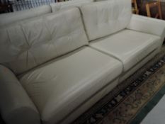 A modern cream leather lounge suite comprising two settees (approx widths 244 and 174cm) and an