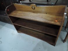 An Arts and Crafts oak open low bookcase, interesting detailing including metal bosses to shelf