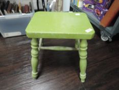 A traditional low milking style stool painted in green