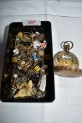 A vintage lidded box containing a small selection of misc including cigar cutter, dice, chains,