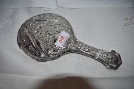 An Edwardian silver hand mirror having moulded floral decoration, Birmingham 1905 (AF)