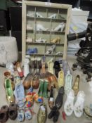 A selection of miniature display shoes and boots in case etc
