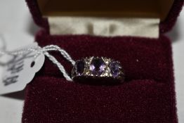 A lady's dress ring having three amethysts in a gallery mount on an HM silver loop, size O