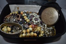 A vanity case containing a selection of costume jewellery