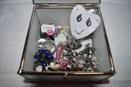 A decorative box containing a selection of stud and clip fashion earrings etc