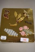 A selection of costume jewellery brooches including holly leaf
