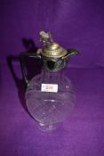 A cut glass claret jug of oval form having chequered decoration and plated handle and lid with