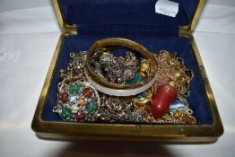 A small travel jewellery case containing a selection of costume jewellery including bangles,