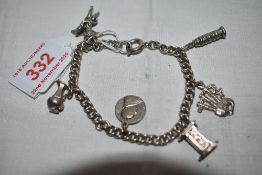 A white metal curb chain bracelet stamped silver having six white metal charms