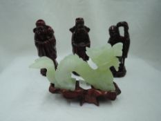 A hand carved figure of a Chinese dragon in a pale green jade and similar figures