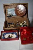 A treen box containing a selection of cufflinks, tie clips, tie tacs, etc