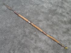 A tribal spear having leather and hide handle wrough iron head and tip possibly from the Maasai