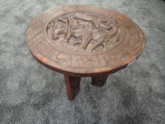 A traditional ethnic wood carved folding table of African design standing 38cm tall
