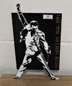 A Freddie Mercury commemorative stand, made from hard plastic, 34cm by 20cm wide.