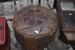 A vintage panelled leather pouffe of circular form, diameter approx. 47cm