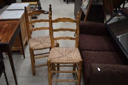 A pair of ladder back rush seated kitchen chairs