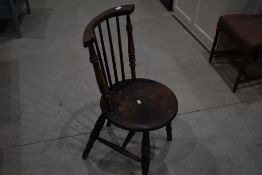 A traditional solid seat kitchen dining chair having turned and stick back