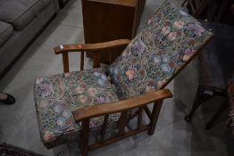 A vintage wood frame recliner chair, having later morris style upholstery