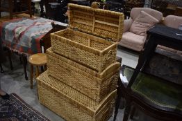 A set of three graduated rushwork domed top storage trunks