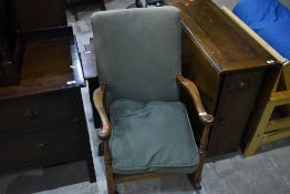 A traditional mahogany framed rocking chair having shaped arms and part turned frame