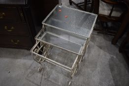A vintage metal and glass nest of tables