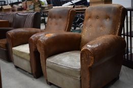 A pair of 1920s leather armchairs, worn patina