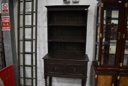 A late 19th/early 20th Century dark oak narrow dresser having mythological drawer handles, width