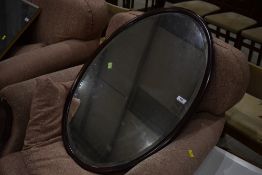 An early 20th Century mahogany oval wall mirror, width approx. 79cm