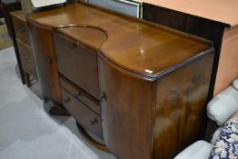 A mid 20th Century walnut sideboard, labelled Beautility, having central cocktail section flanked by
