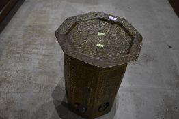 An Indian brass table having extensive embossed mytholgical and naturalistic decoration, the