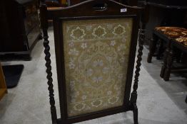 An oak firescreen having needlework inset