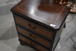 A reproduction mahogany three door bedside chest