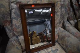 An Arts and Crafts oak wall mirror, labelled on reverse for Arthur Simpson Handicrafts of Kendal,