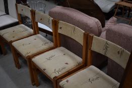 A set of four modern pine dining chairs with upholstered seats and back rails