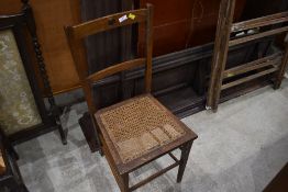 A Victorian oak bedroom chair, having cane seat and heart motif to back rail, in need of