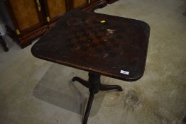 A 19yh Century stained frame pedestal occasional table, with faded chequer board top, some
