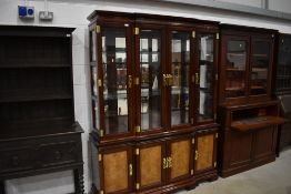 A modern Oriental hardwood bookcase having brass clasps and handles, width approx. 160cm height