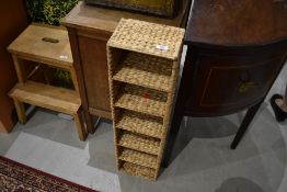 A modern rushwork shelf/CD rack, height approx. 86cm W22cm