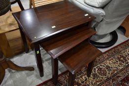 A modern nest of three mahogany tables