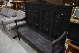 A 19th Century stained frame settle having Lincustra style panel decoration depicting Conquistador/