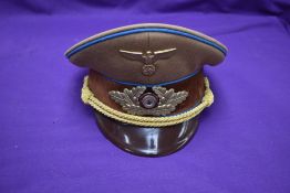 A German WW2 Government Officials Visor Cap ,with eagle and swastika metal badge and swastika and