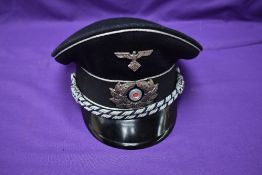 A German WW2 Teno Officers Visor Cap, with metal badges and having celluloid diamond above maker's