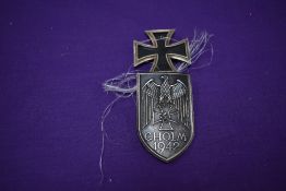 A German WW1 Iron Class first class dated 1914 and a German WW2 Cholm 1942 Shield with eagle and