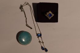 A lady's Art Deco style dress ring having a blue paste stone within a clear paste square border in a